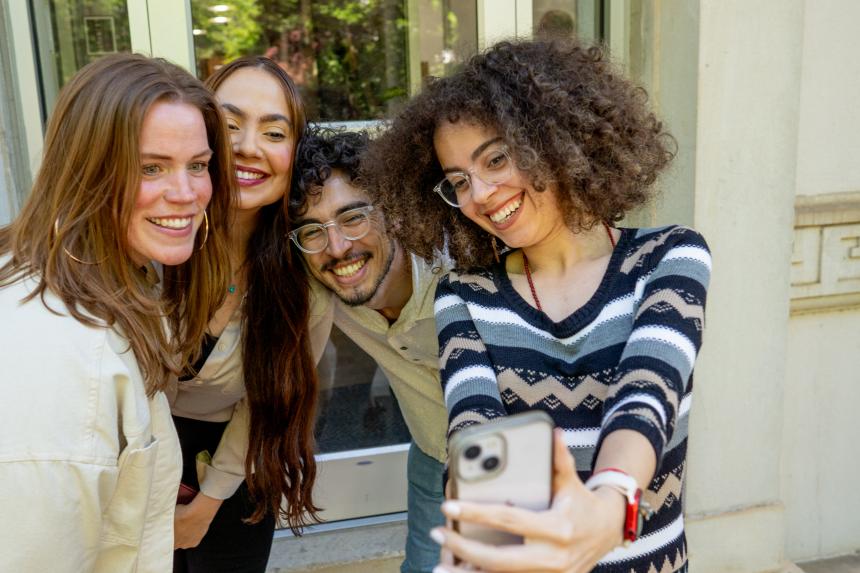 Students Take a Selfie and Smile In Front of the Door of Gilbert Hall