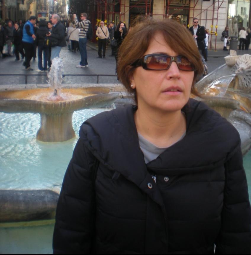 A person standing in front of a fountain</p>
<p>Description automatically generated